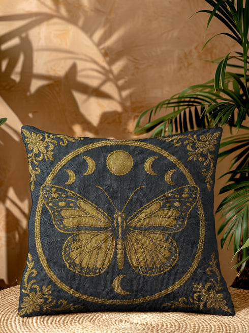 A square woven tapestry pillow in charcoal grey and metallic gold thread, embodying a premium, artisan feel. The central design features an intricate butterfly, a nod to entomology decor, encircled by a celestial moon phase motif. This combination of mystical and dark botanical elements makes it ideal for Whimsigoth, Gothic, and Dark Academia aesthetics. Ornate Victorian flourishes in the corners complete this luxurious, double-sided piece of functional art.